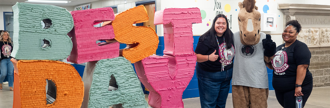 teachers posing with mustang mascot